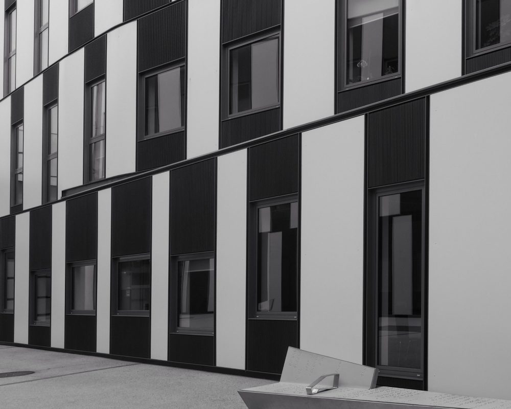A grayscale shot of a striped apartment building